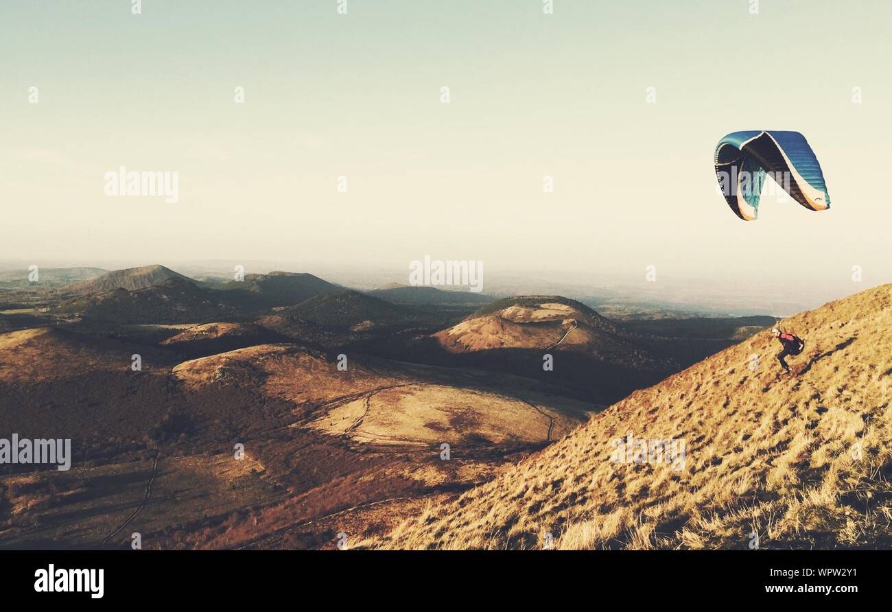 Parachuting Over Rocky Landscape Stock Photo