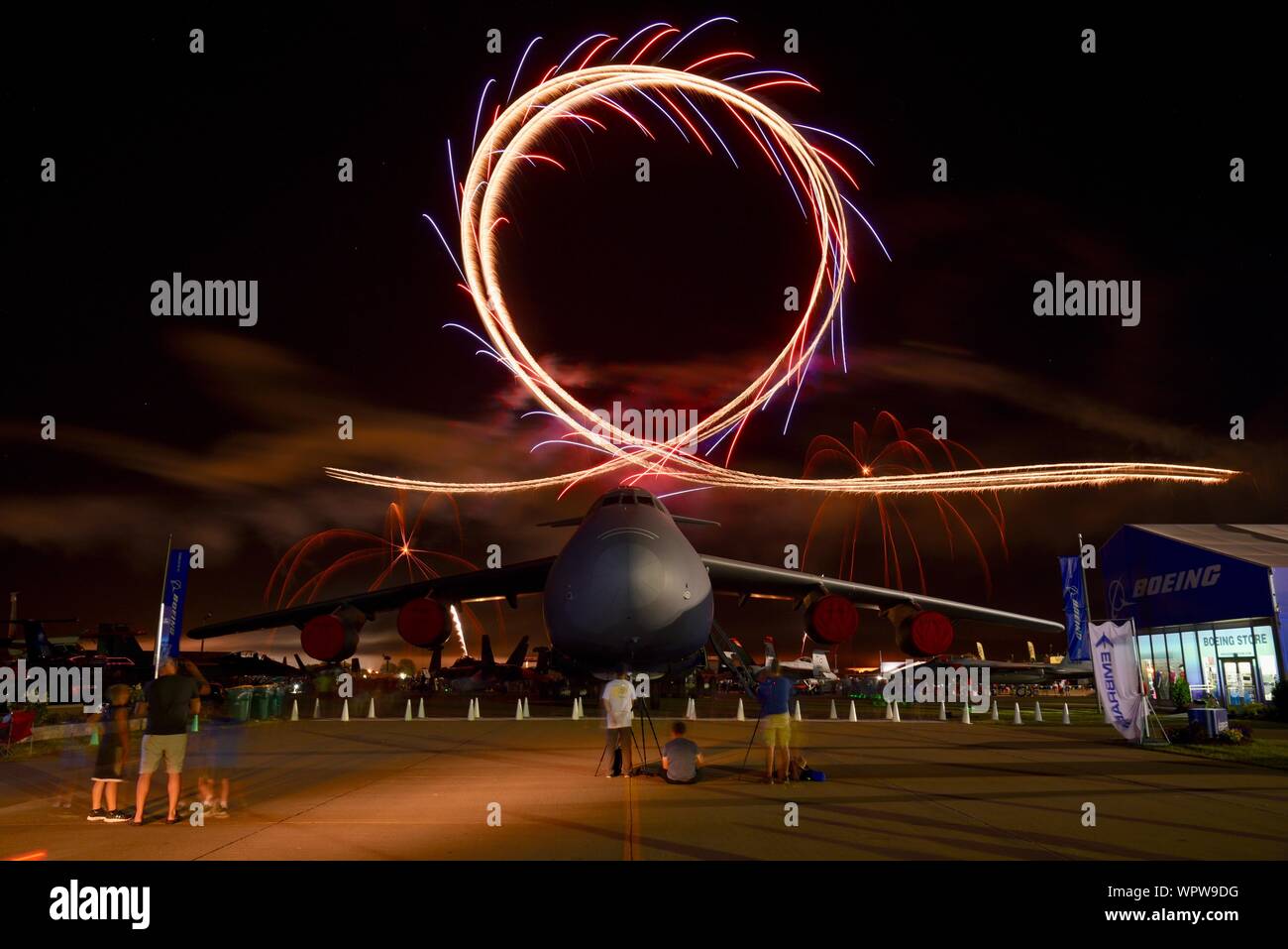 Spectacular fireworks explode behind massive Lockheed C-5M Super Galaxy aircraft parked in Boeing Plaza of EAA AirVenture, Oshkosh, Wisconsin, USA Stock Photo