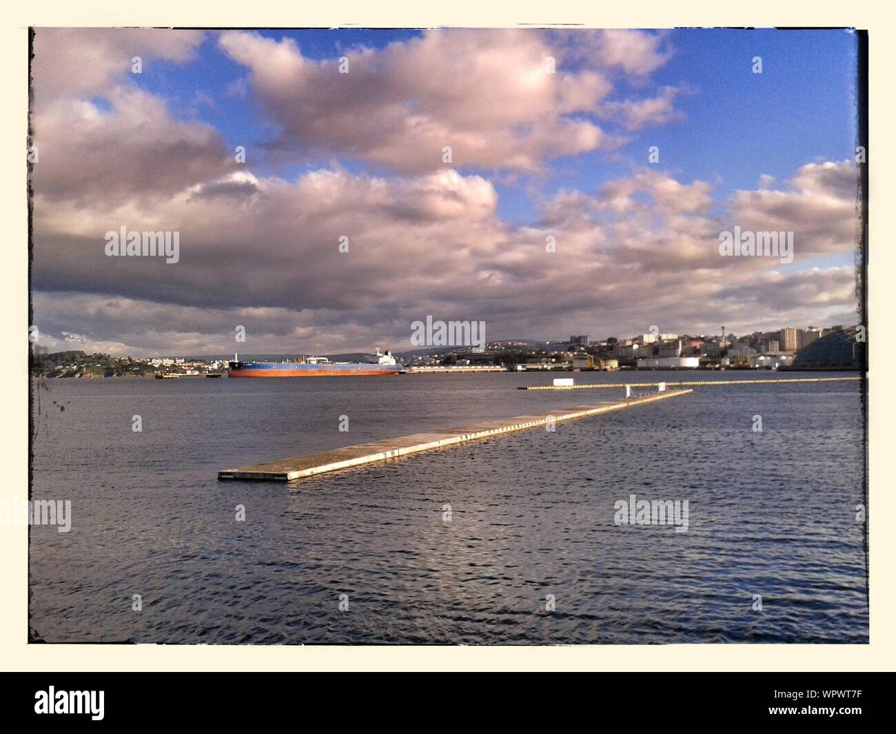Wooden Platforms On Sea At Shipping Industry Against Cloudy Sky Stock Photo