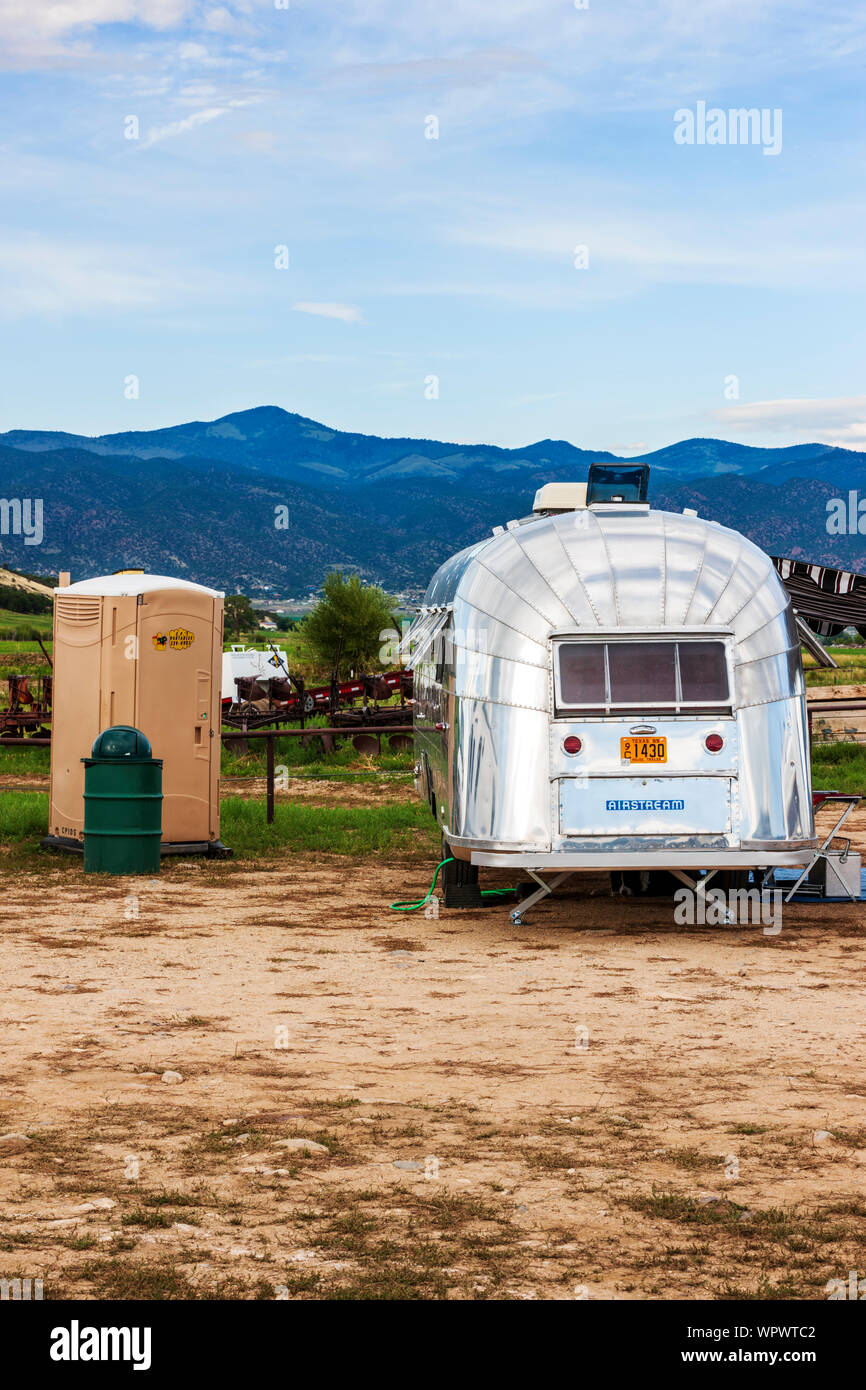 portable toilet outhouse next to Airstream camping trailer at the Vintage Airstream Club Rocky Mountain Rally Stock Photo