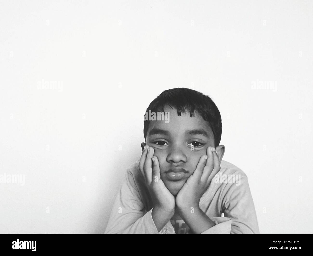 Portrait Of Boredom Boy Against White Background Stock Photo