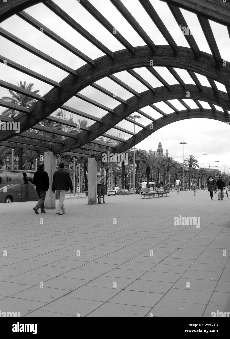 People Walking Under Architectural Ceiling On Sidewalk Stock Photo