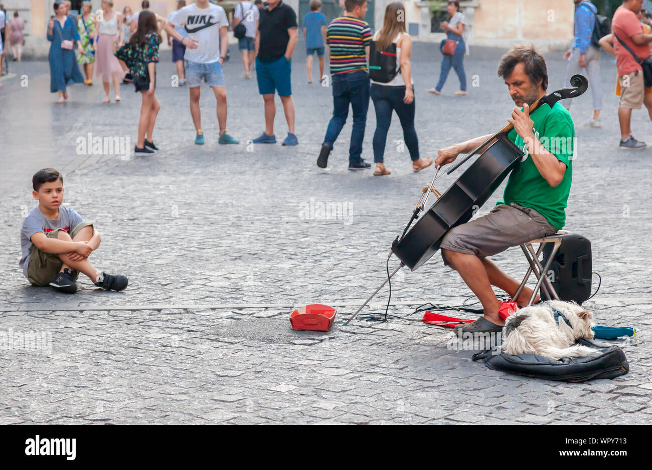 Street musician with child and dog. Rome, Italy. Stock Photo