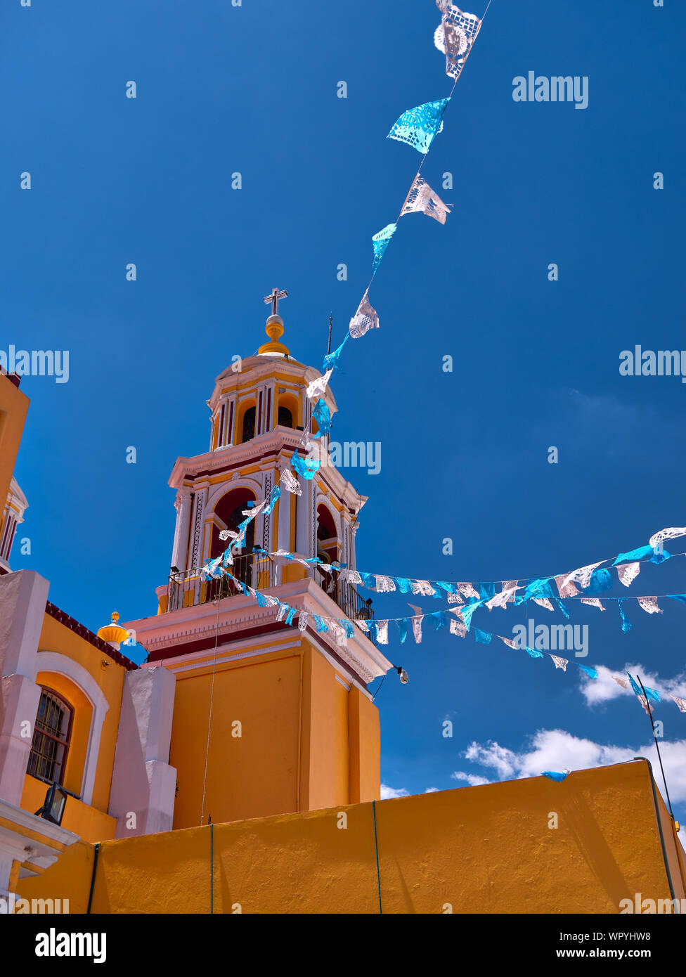 Yellow bell tower of Shrine of Our Lady of Remedies sanctuary in San Pedro Cholula with blue sky Stock Photo