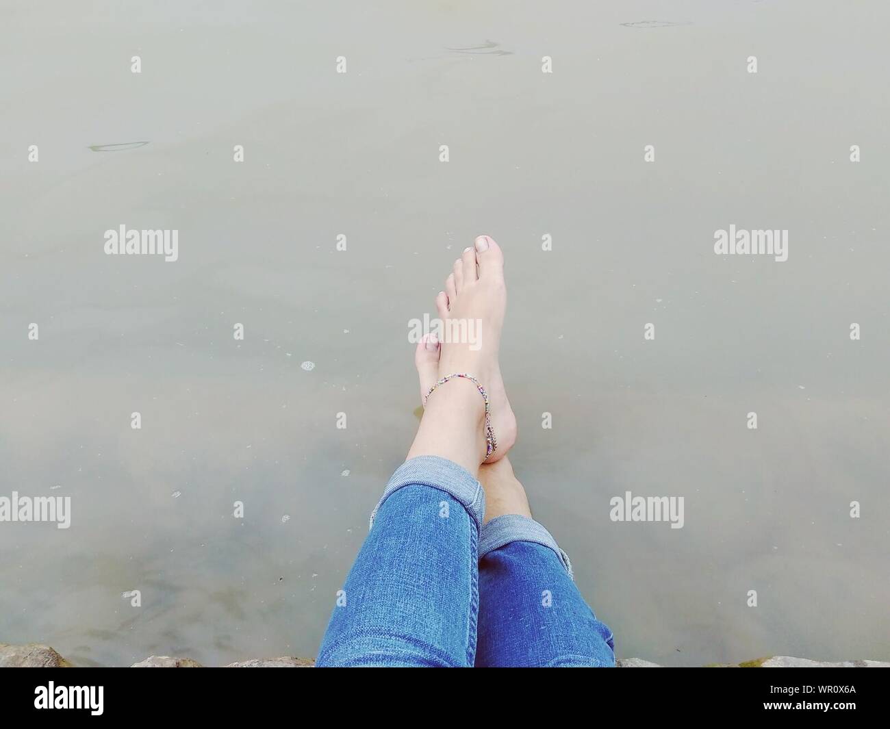 Low Section Of Legs Crossed At Ankle Stock Photo Alamy