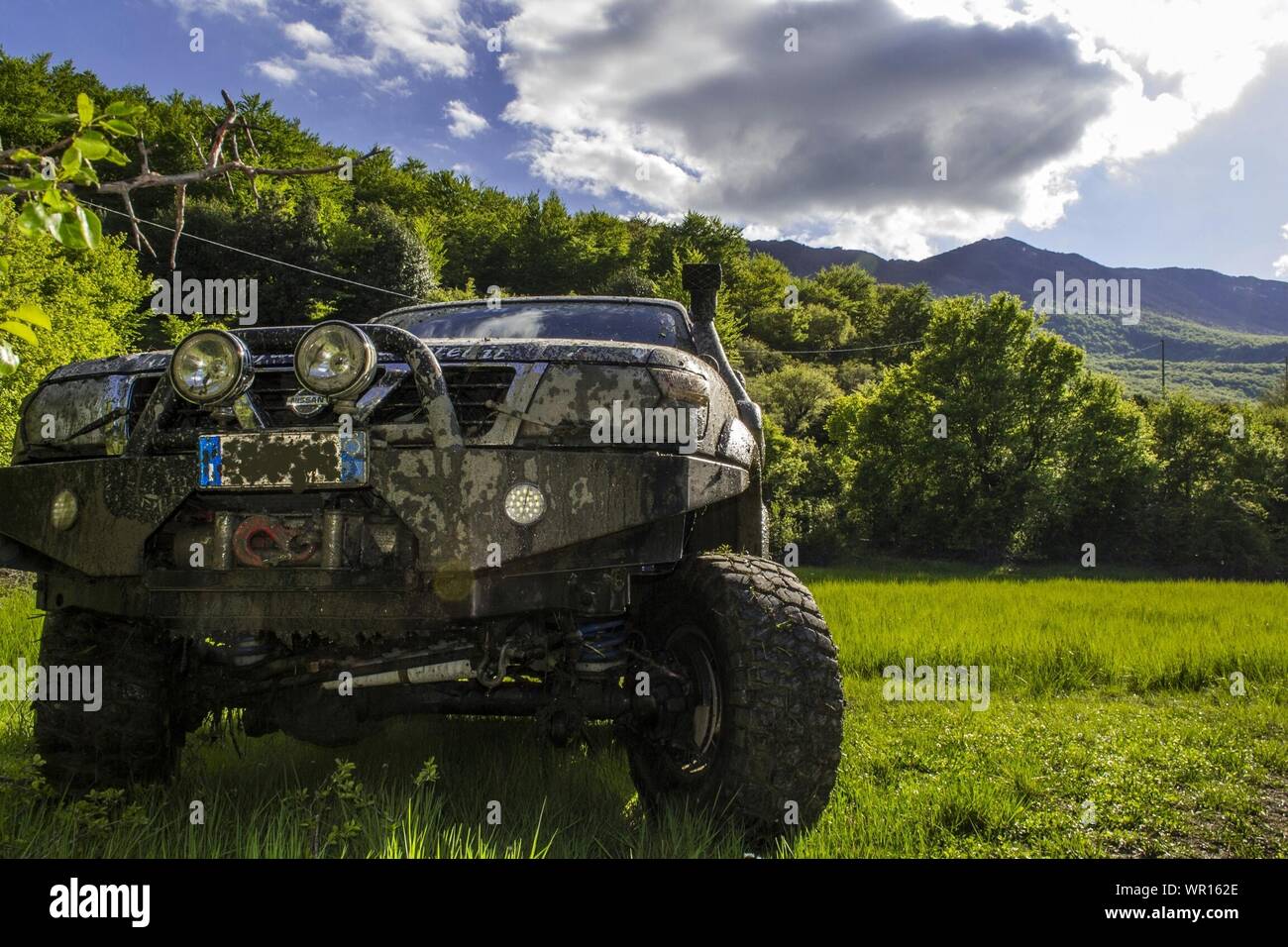 Dirty Sport Utility Vehicle On Grassy Field Stock Photo
