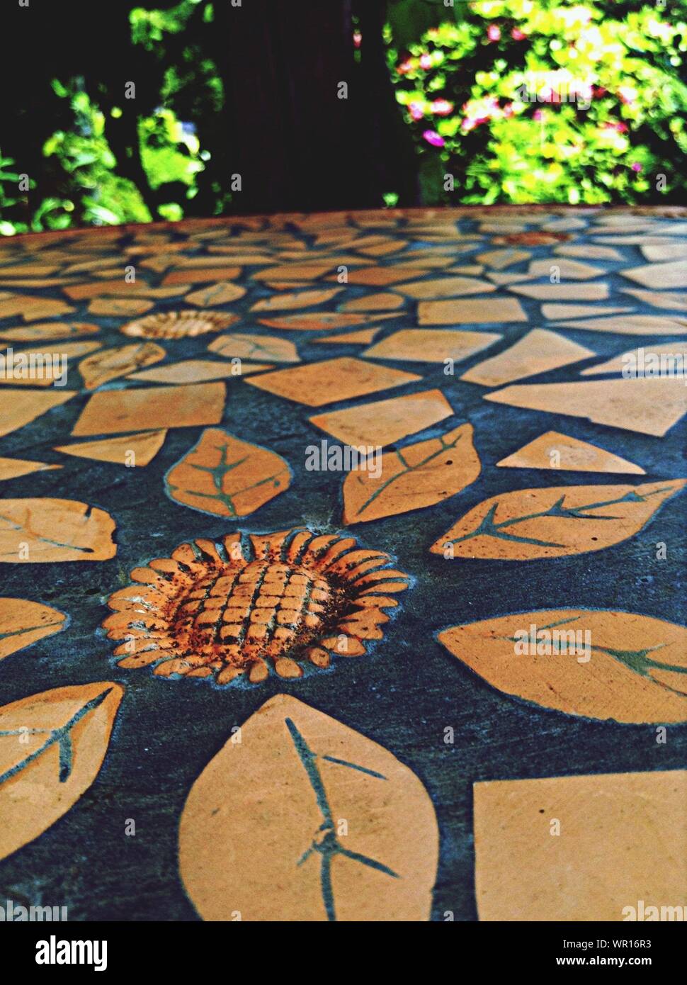 Leaves And A Sunflower Pattern Etched Into A Tabletop Stock Photo