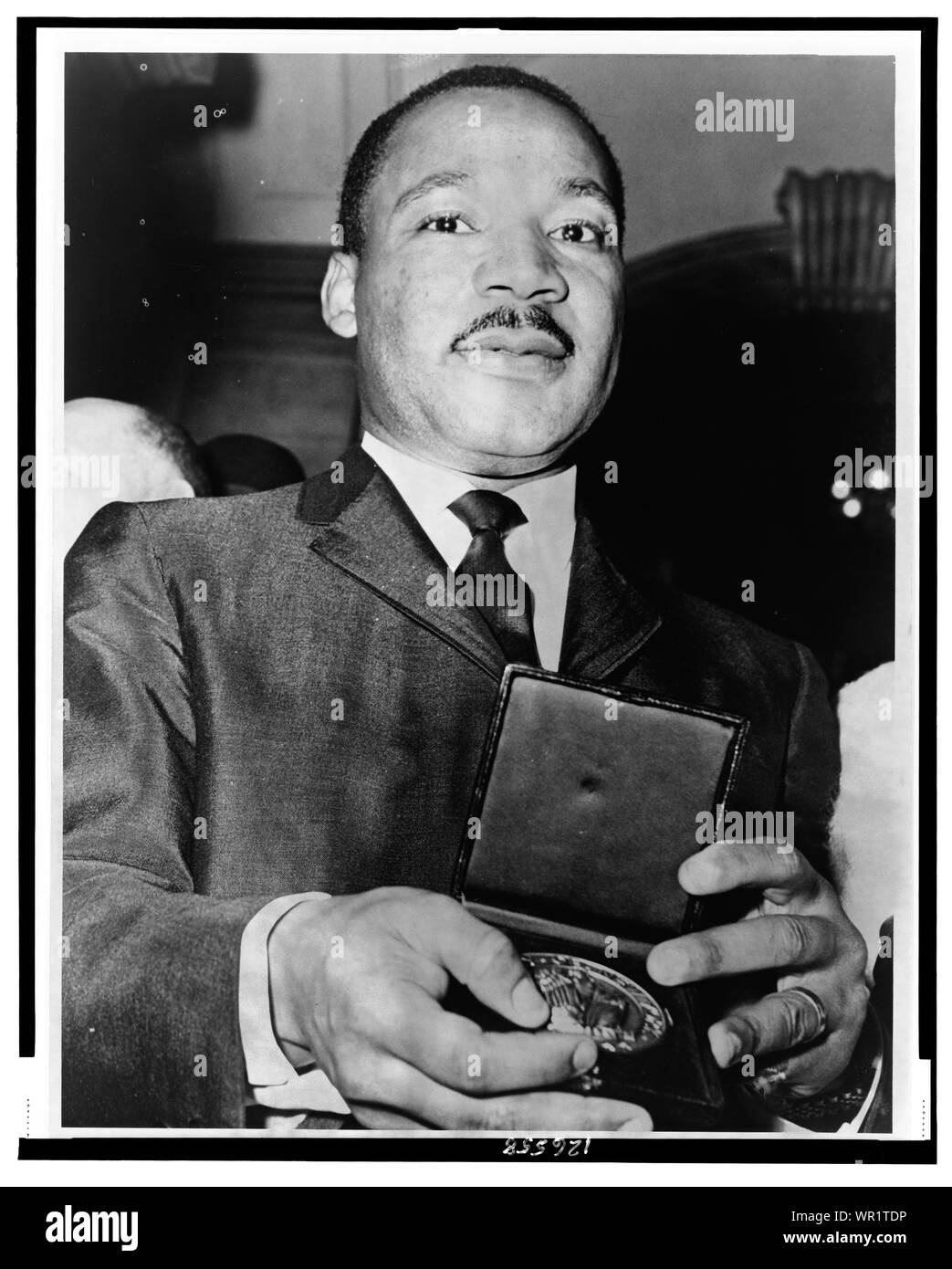 Martin Luther King, Jr. showing his medallion received from Mayor Wagner.; Stock Photo