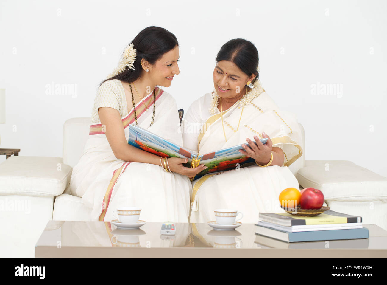 Old woman with her daughter looking at family photo album Stock Photo ...