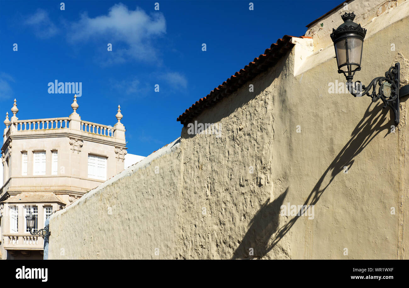 Electric Lamp On Wall Against Sky During Sunny Day Stock Photo