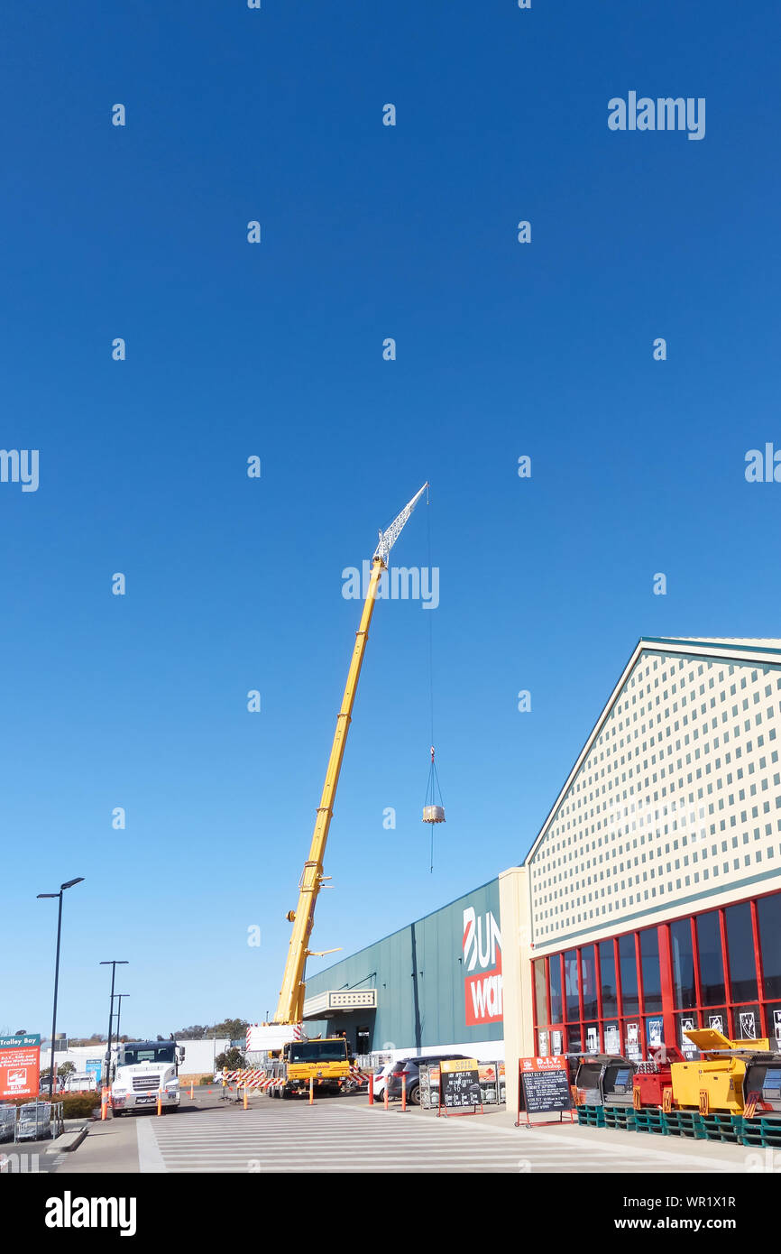 Tall crane lifting goods over the roof of Bunnings hardware store in
