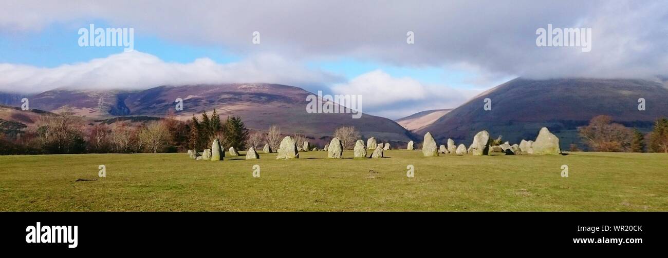 Scenic View Of Stone Formations In Field With Mountains In Background Stock Photo