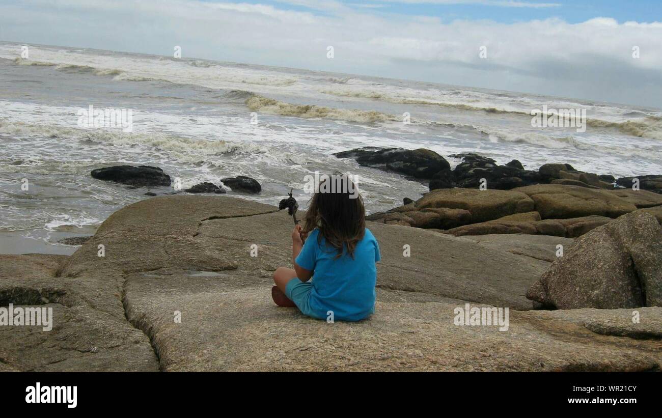 Girl rear view sitting rock hi-res stock photography and images - Alamy