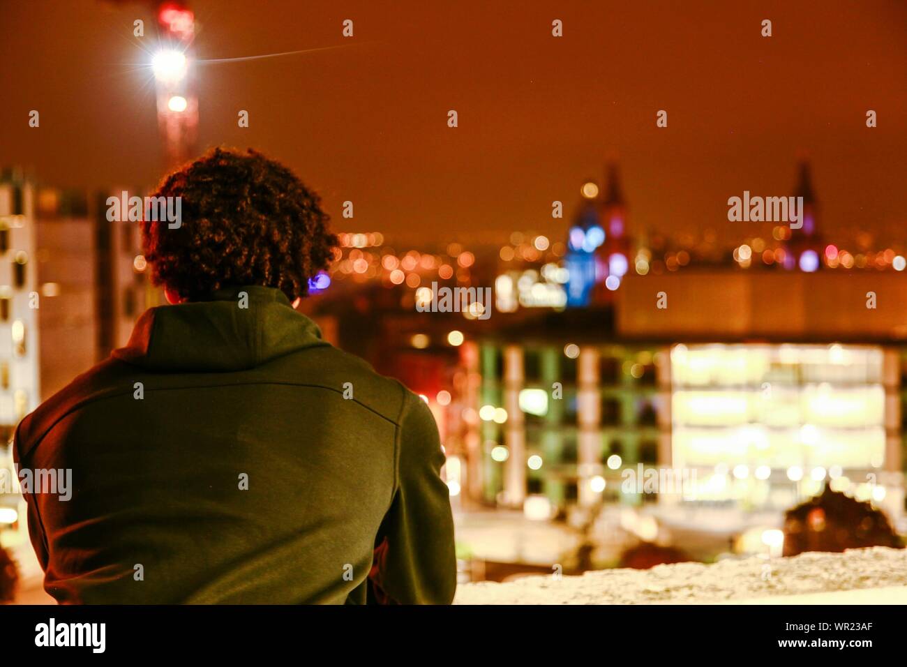 Rear View Of A Man On Balcony Looking At City At Night Stock Photo Alamy