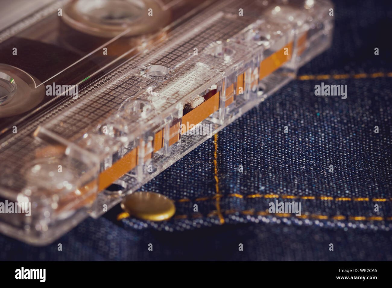 Cassette tape audio on jeans fabric in darkness. Concept of vintage 90s