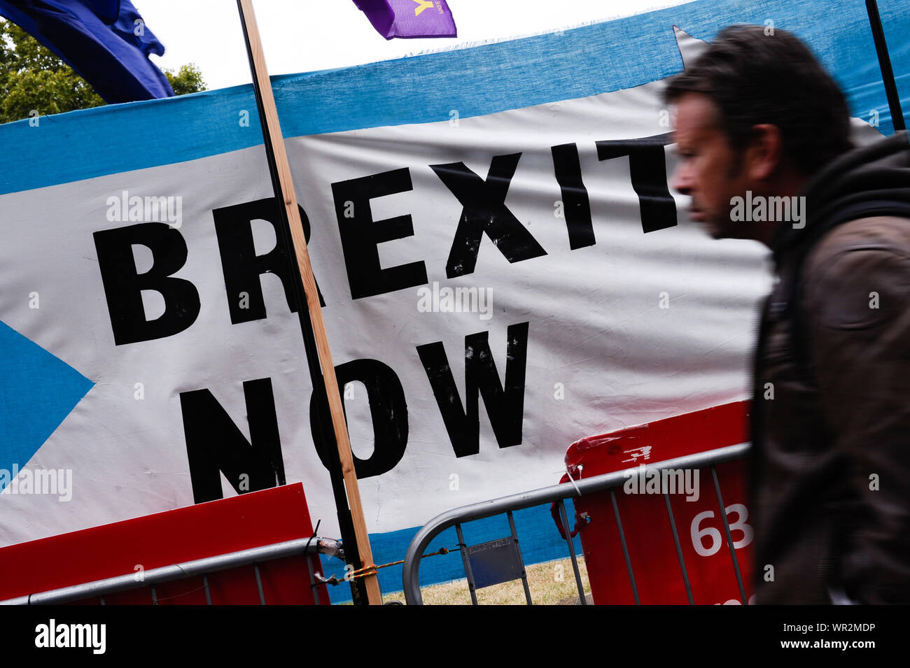 London, UK. 09th Sep, 2019. A man walks past a Brexit Party banner calling for 'Brexit Now' outside the Houses of Parliament in London on the day of the prorogation of the parliamentary session, which will see parliamentary activities suspended until mid-October. Credit: SOPA Images Limited/Alamy Live News Stock Photo