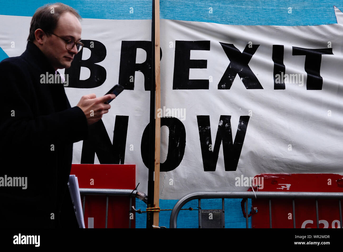 London, UK. 09th Sep, 2019. A man walks past a Brexit Party banner calling for 'Brexit Now' outside the Houses of Parliament in London on the day of the prorogation of the parliamentary session, which will see parliamentary activities suspended until mid-October. Credit: SOPA Images Limited/Alamy Live News Stock Photo