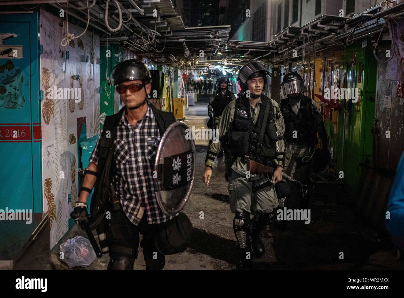 A group of riot police searches for protesters in alleys of Causeway Bay during the demonstrations.After 14 weeks of protests, demonstrations have continued across Hong Kong despite the withdrawal by Chief Executive, Carrie Lam of a controversial extradition bill. Protests keep taking the streets as demonstrators demands the city's government to attend to their demands, including an independent inquiry into police brutality, the retraction of the word 'riot' to describe the rallies, and the right for Hong Kong people to vote for their own leaders. Stock Photo