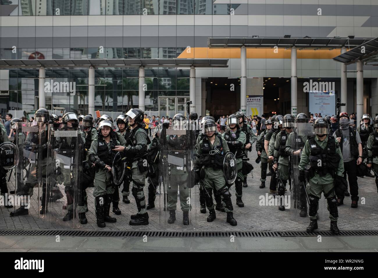 A group of riot police occupy a square in Tung Chung during the protests.After 14 weeks of protests, demonstrations have continued across Hong Kong despite the withdrawal by Chief Executive, Carrie Lam of a controversial extradition bill. Protests keep taking the streets as demonstrators demands the city's government to attend to their demands, including an independent inquiry into police brutality, the retraction of the word 'riot' to describe the rallies, and the right for Hong Kong people to vote for their own leaders. Stock Photo