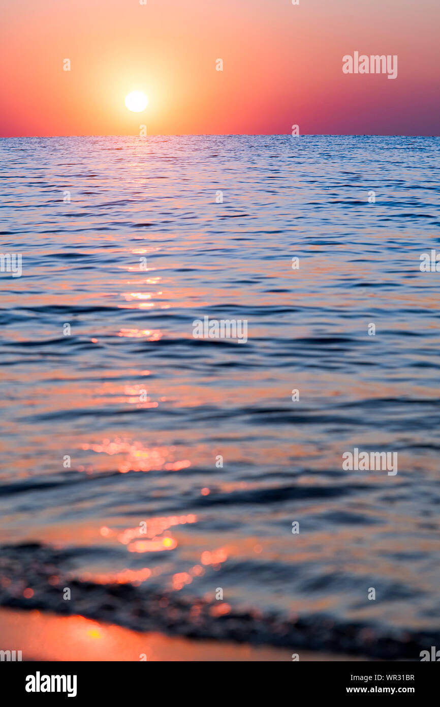 Bright sunset with large yellow sun under the sea surface Stock Photo