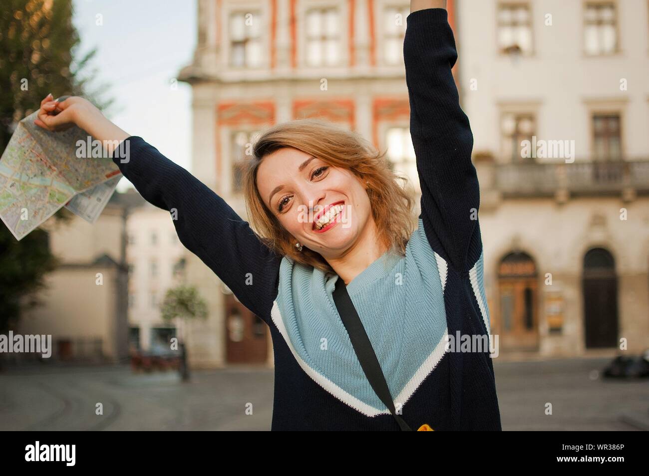Outdoors portrait of young happy girl with blonde hair and blue casual clothes is standing on the square of ancient city in Europe with map Stock Photo - Alamy Outdoors portrait of young happy girl with blonde hair and blue casual clothes is standing on the square of ancient city in Europe with map Stock Photo - Alamy