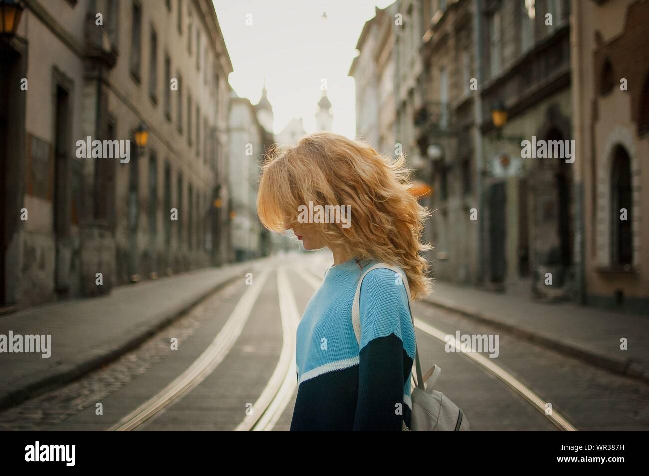 Side view of beautiful young adult girl tourist enjoying her trip early