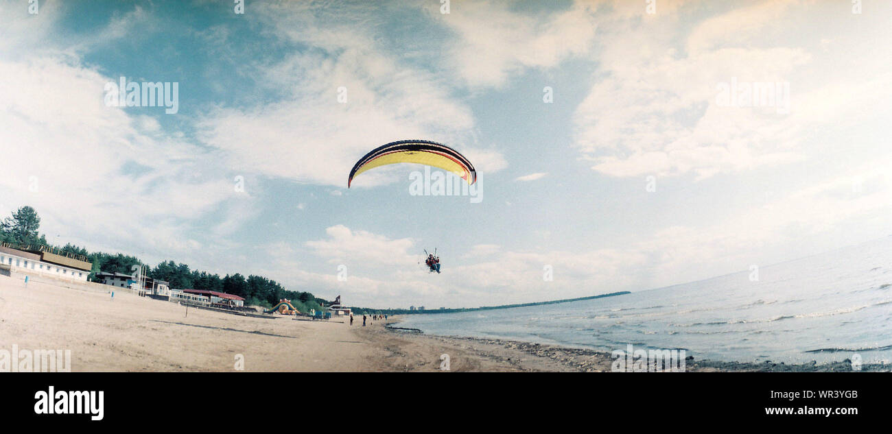 Skydiver On Parachute Over Sandy Beach Stock Photo