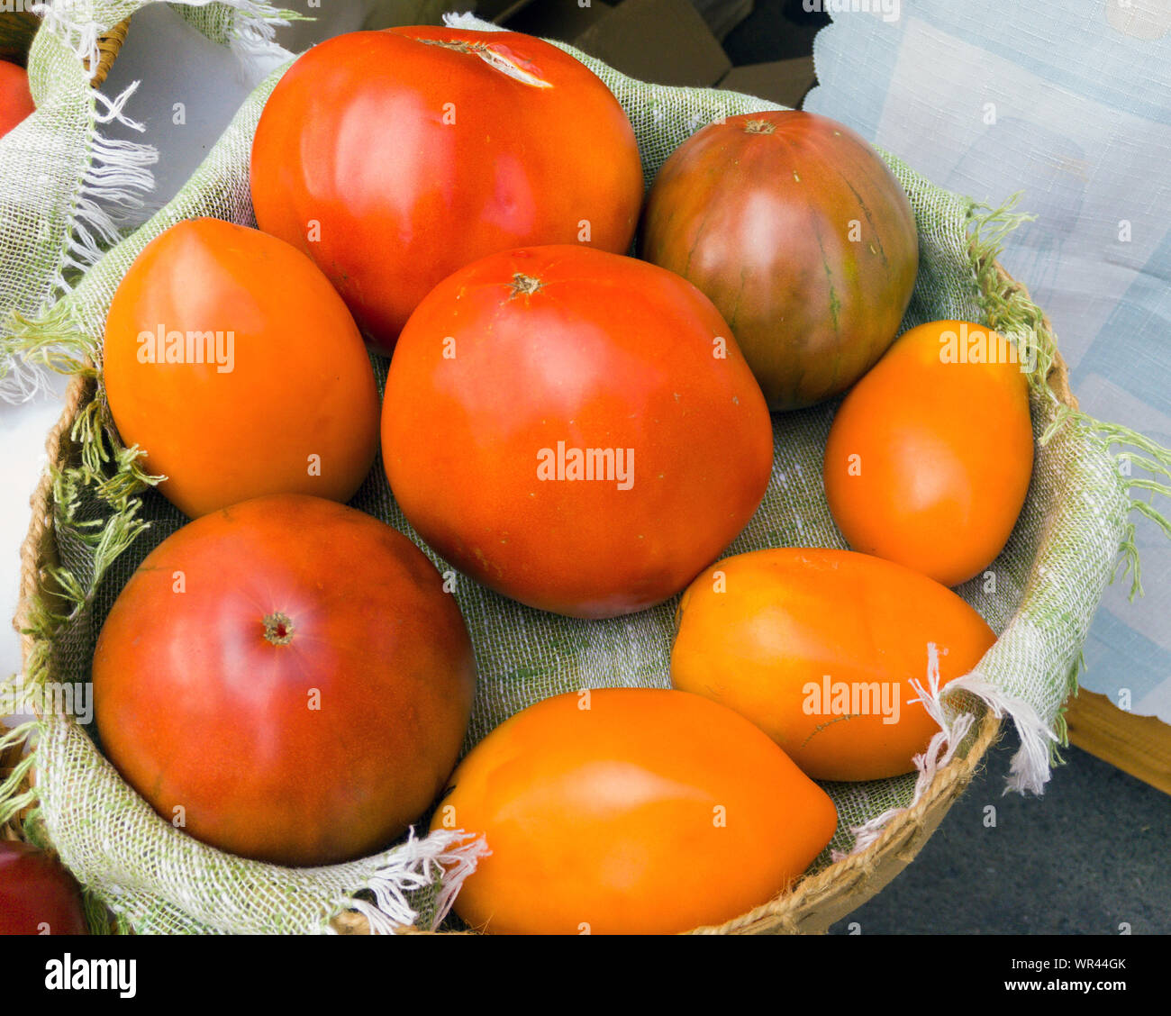 Selected fresh tomatoes in a wicker basket in the market Stock Photo ...