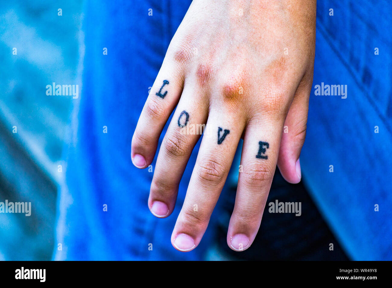 Cropped Image Of Hand With Love Text Tattoo Stock Photo - Alamy