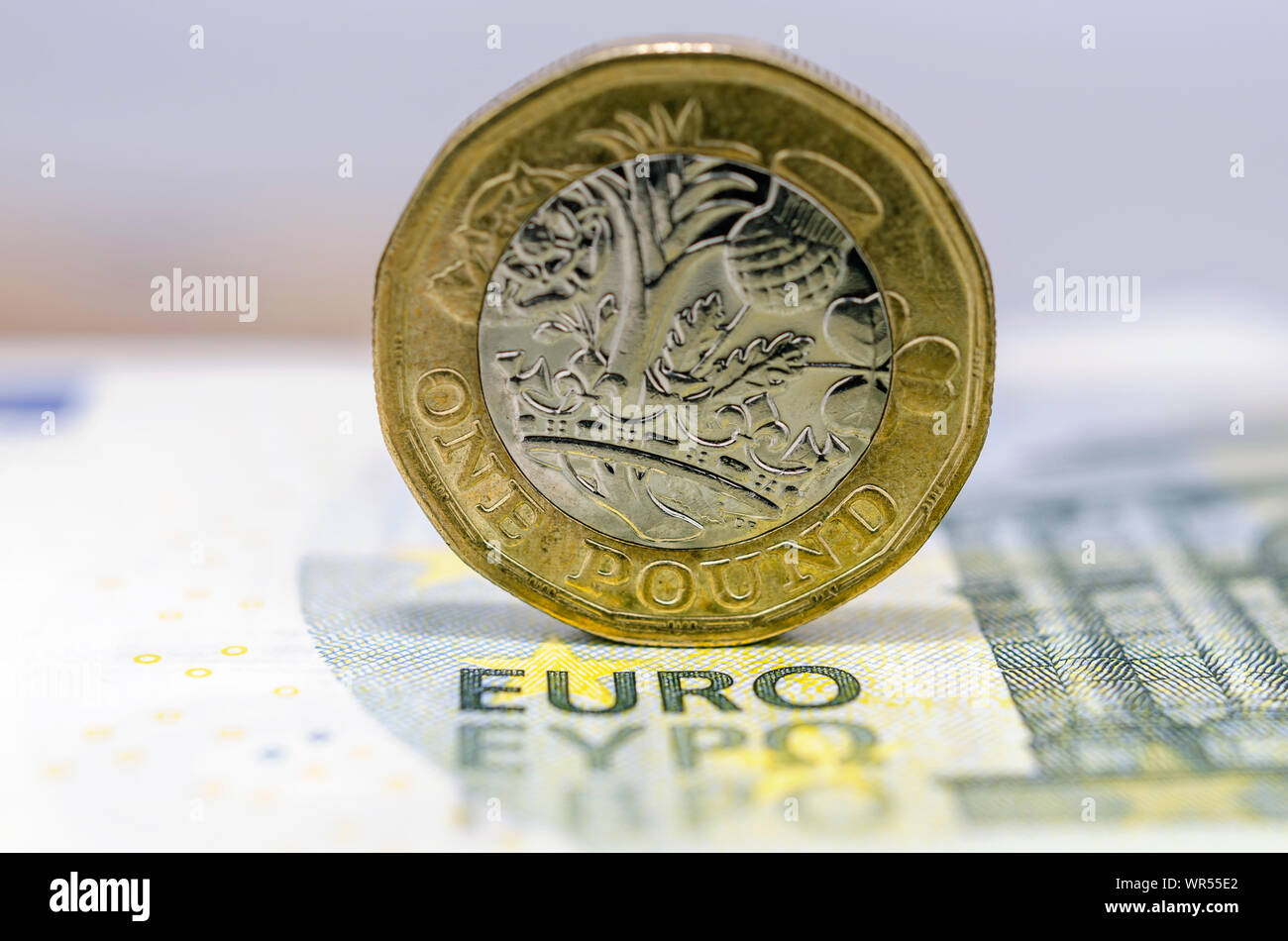 One pound coin on top of 5 Euro banknote. Concept for currency exchange, finance and BREXIT. Macro photo with shallow depth of field. Stock Photo
