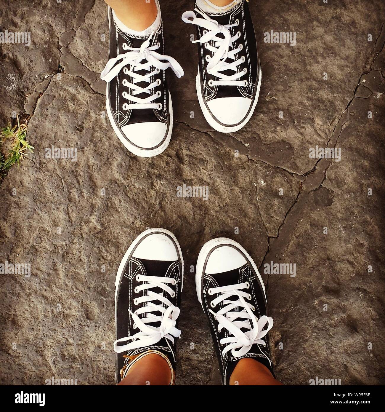 Low Section Of People Wearing Identical Shoes Stock Photo