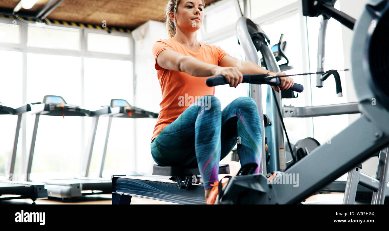 Workout woman cross training exercising cardio using rowing machine Stock Photo
