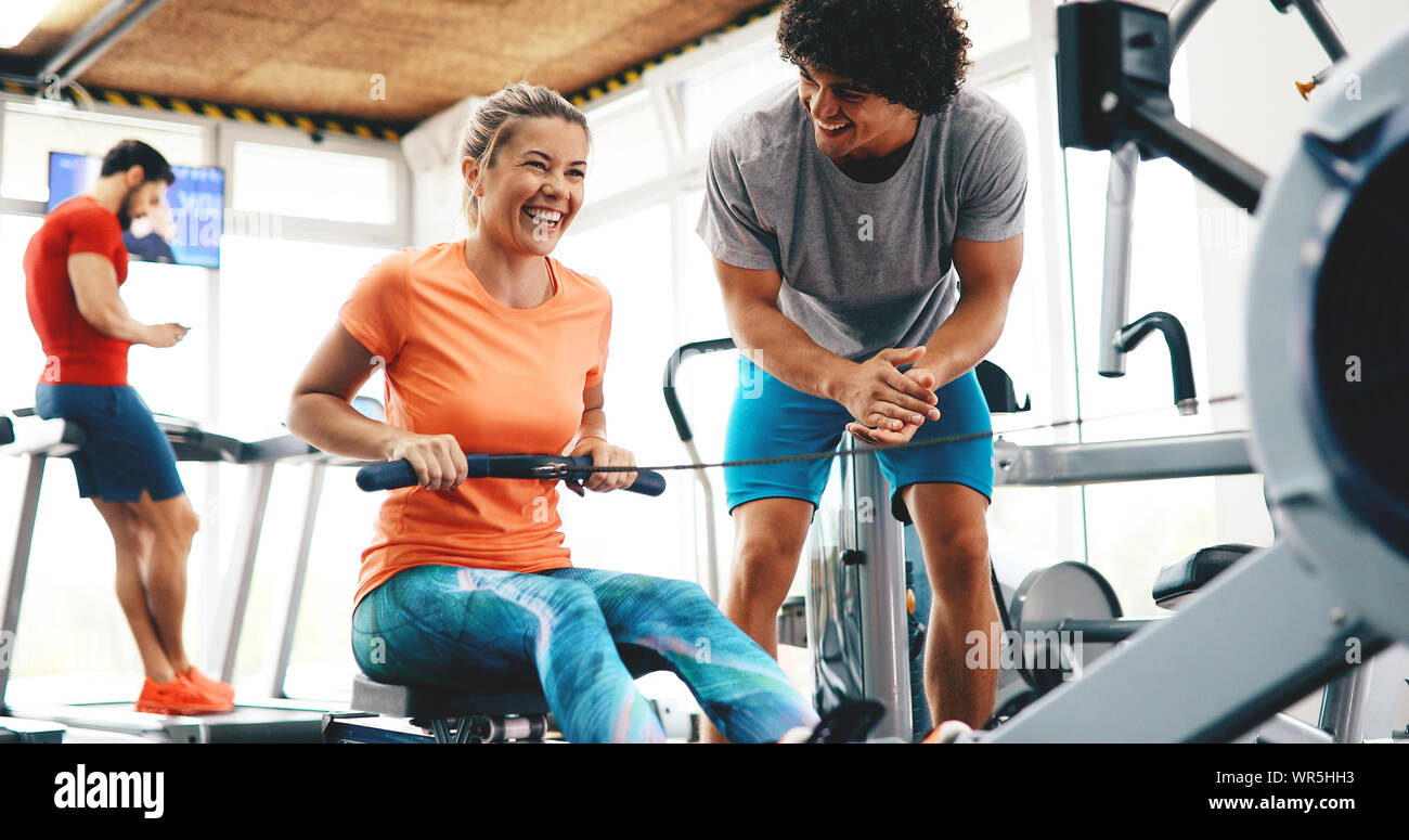 Young beautiful woman doing exercises with personal trainer Stock Photo