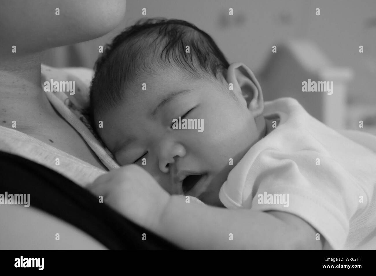 Woman carrying sleeping child Black and White Stock Photos & Images Alamy