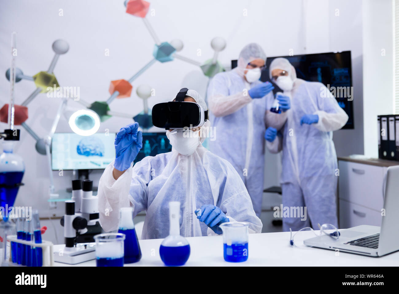 Female scientist using virtual reality goggles simualtion for chemical ...