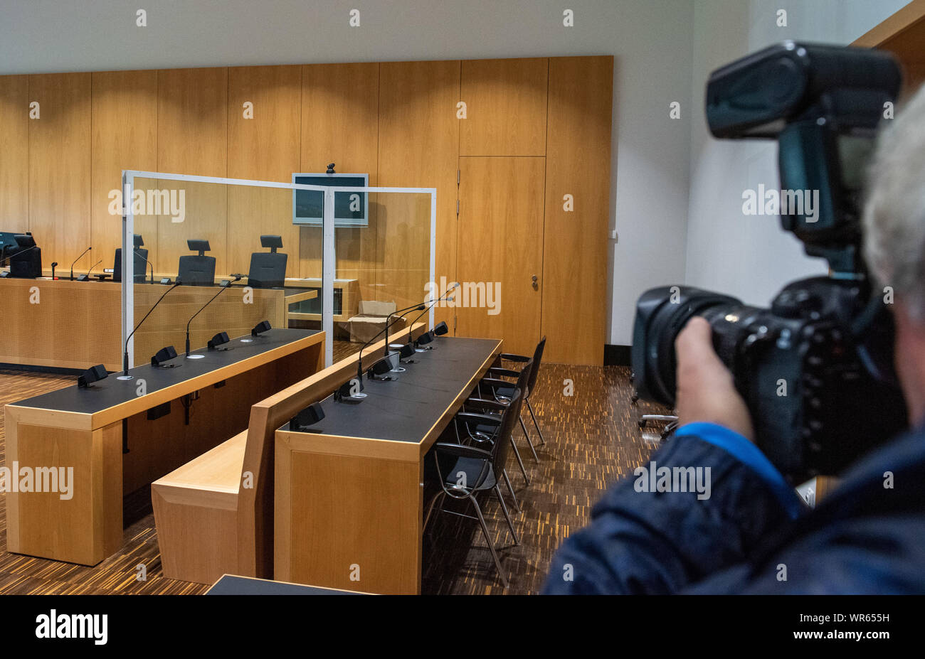 10 September 2019, Bavaria, Augsburg: At the regional court in Augsburg, a journalist photographs the empty dock before the trial against the professional soccer player Caiuby. The Brazilian is said to have given a headbutt to a man and seriously injured the victim. The public prosecutor's office had obtained a penalty order against the professional for intentional bodily injury over a total of 135 daily rates. As the footballer has lodged an appeal, the case is now being heard in public. Caiuby did not appear in court. Photo: Stefan Puchner/dpa Stock Photo