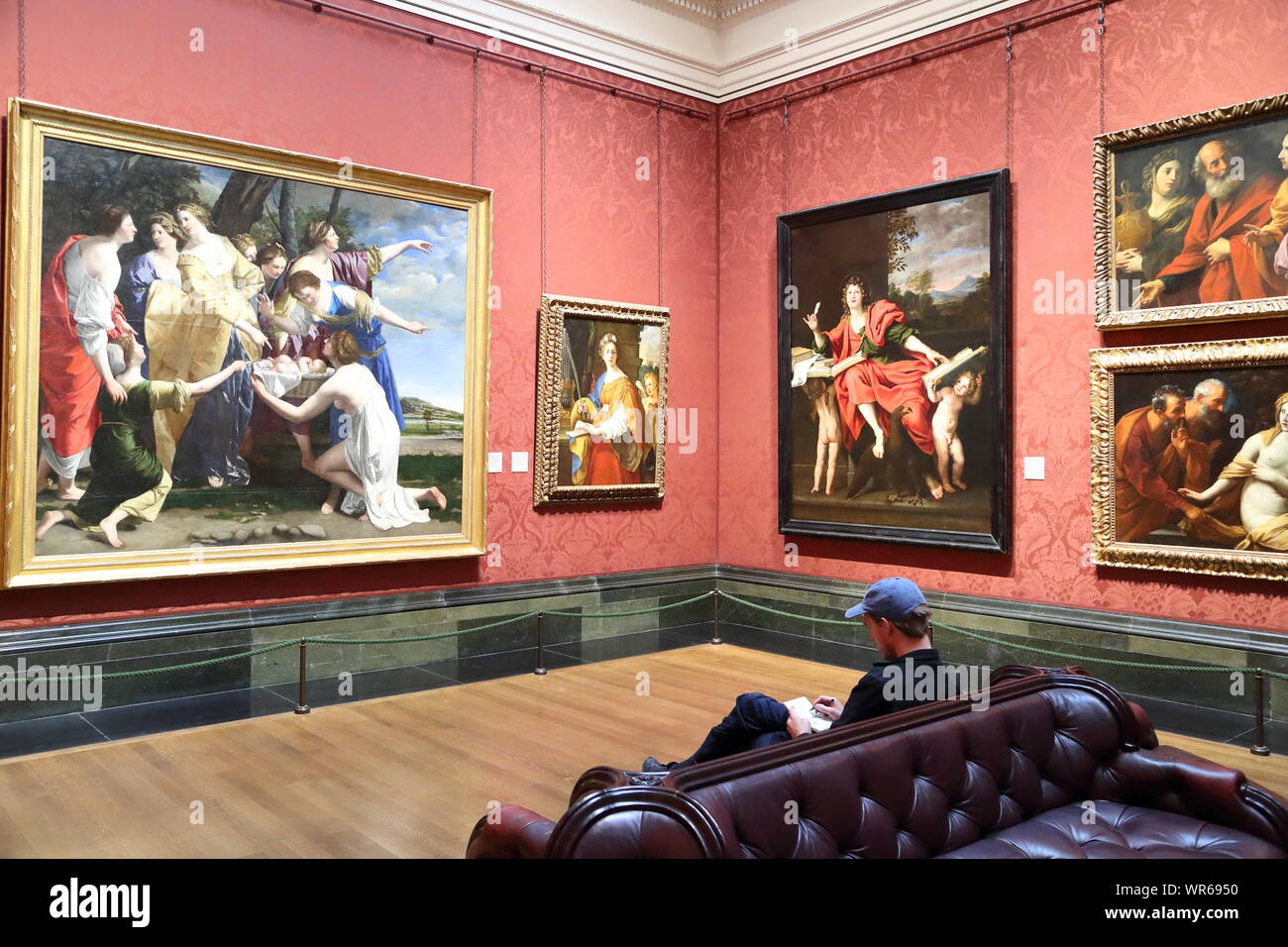 A young man sitting and studying Baroque paintings at the National Gallery, London, UK Stock Photo