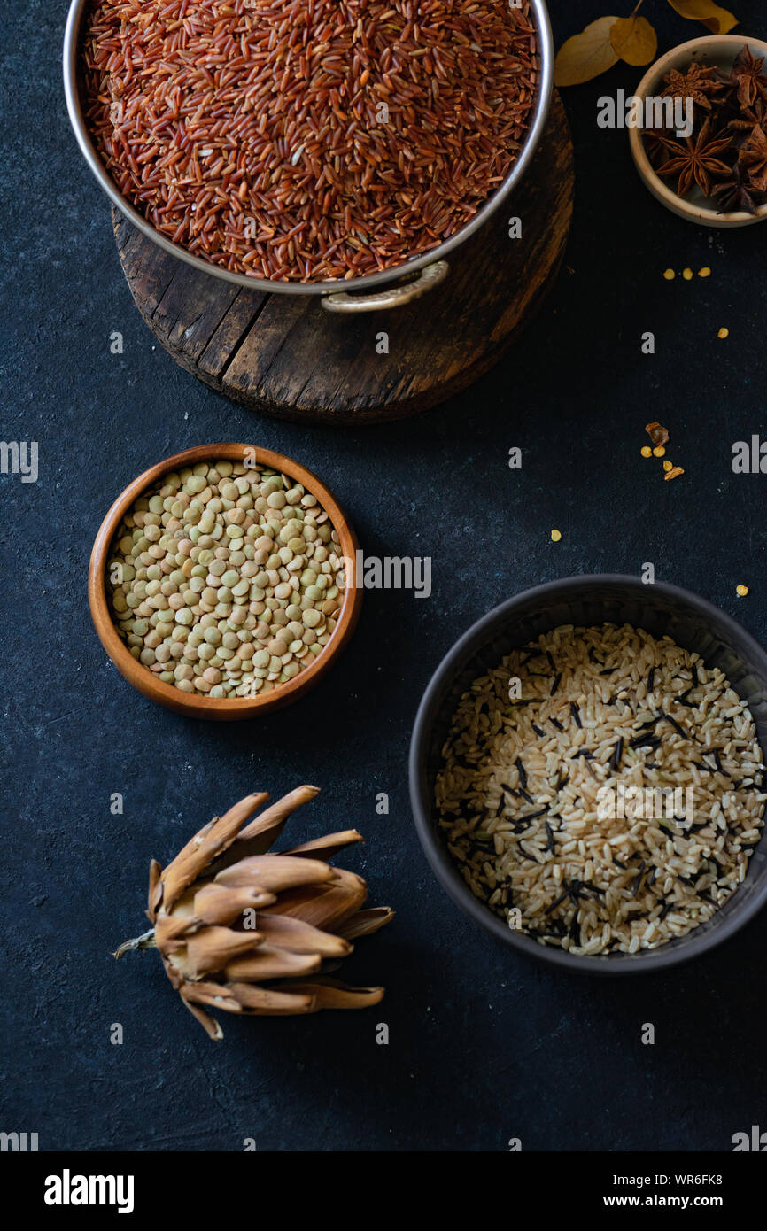 Various types of rice and grains with spices on blue background. Brown