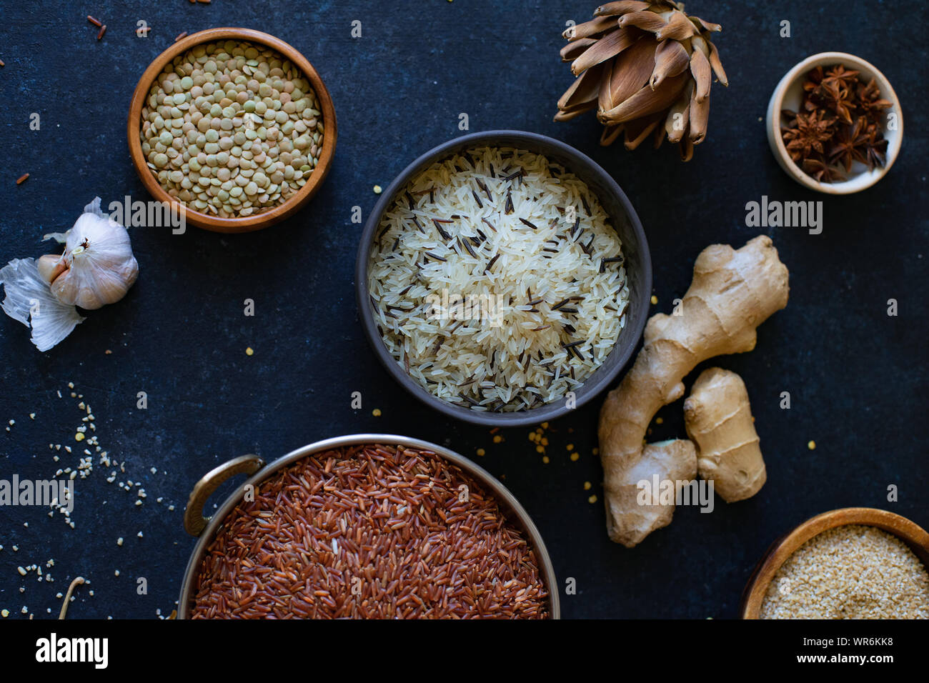Various types of rice and grains with spices on blue background. Brown ...