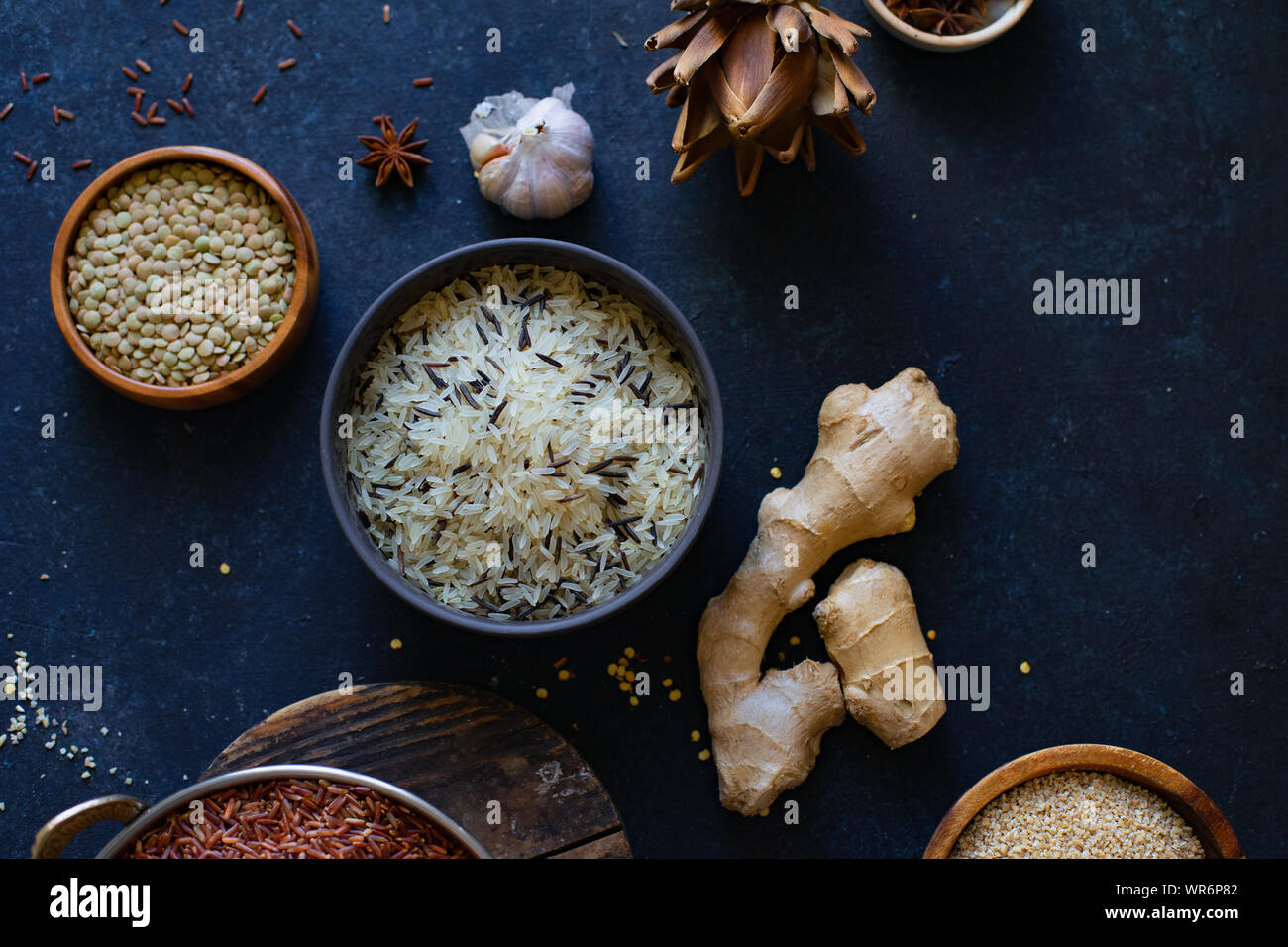 Various types of rice and grains with spices on blue background. Brown