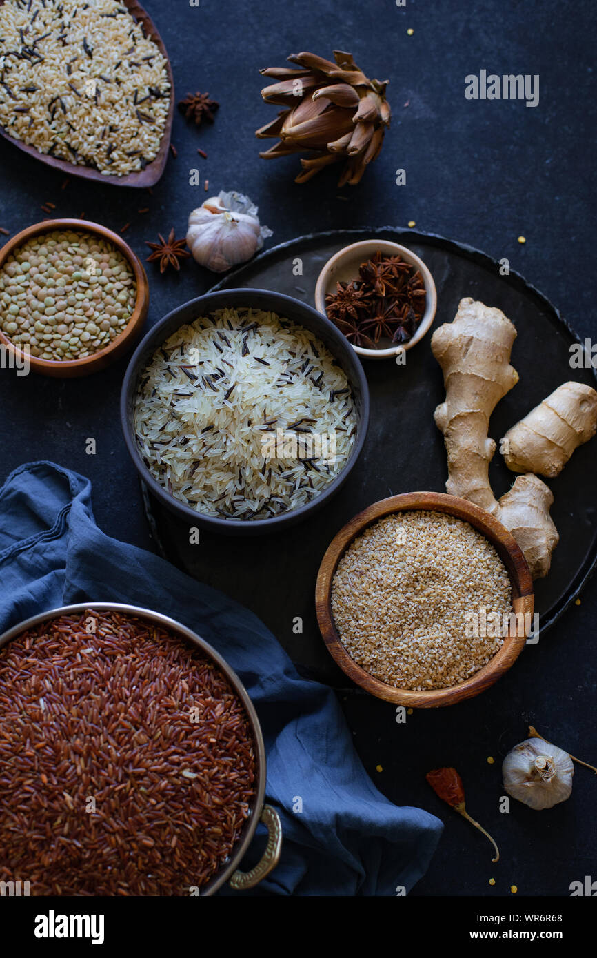 Various types of rice and grains with spices on blue background. Brown ...