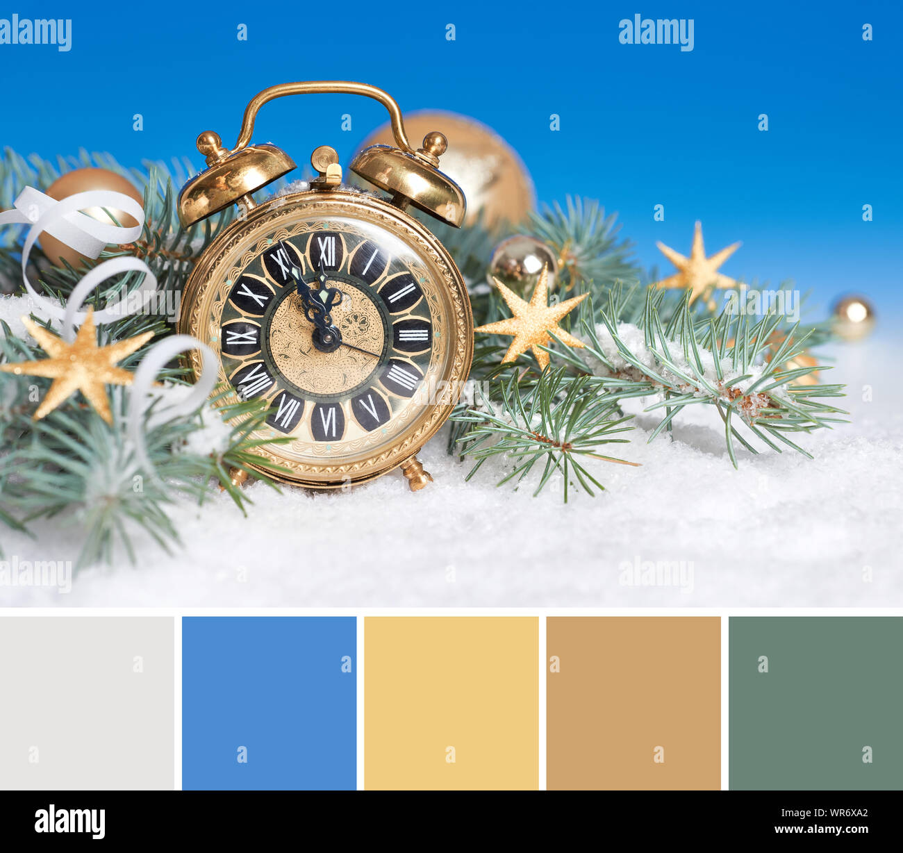 Color matching palette from an old alarm clock set to five to twelve with golden winter decorations Stock Photo