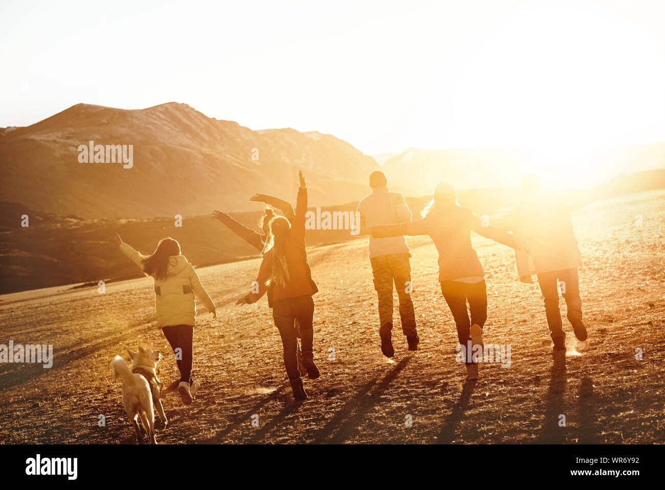 Group of happy friends or travellers is having fun in sunset light. Travel together concept Stock Photo