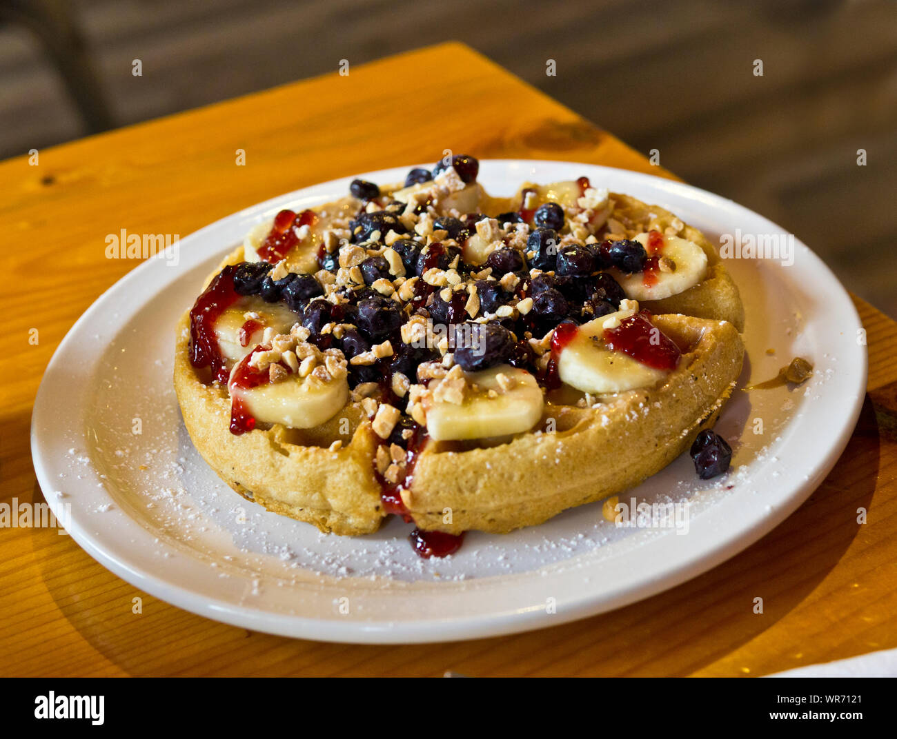 The "Veganessa" vegan waffle at Scandilicious restaurant in Vancouver, BC, Canada. Vegan waffle with peanut butter, jam, blueberries, and bananas. Stock Photo