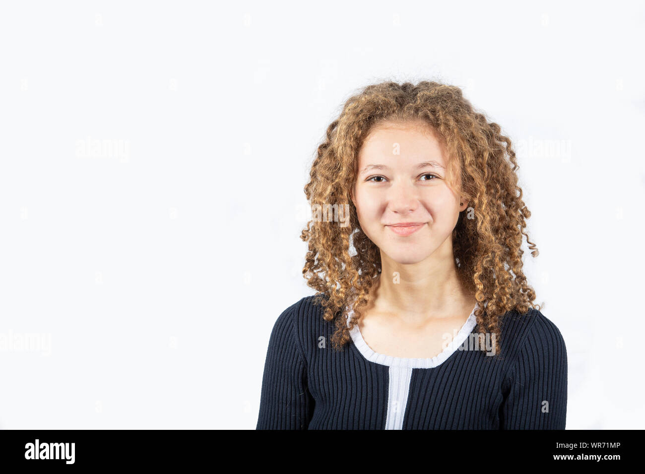 Portrait of happy teenage girl with curly hair smiling looking at ...
