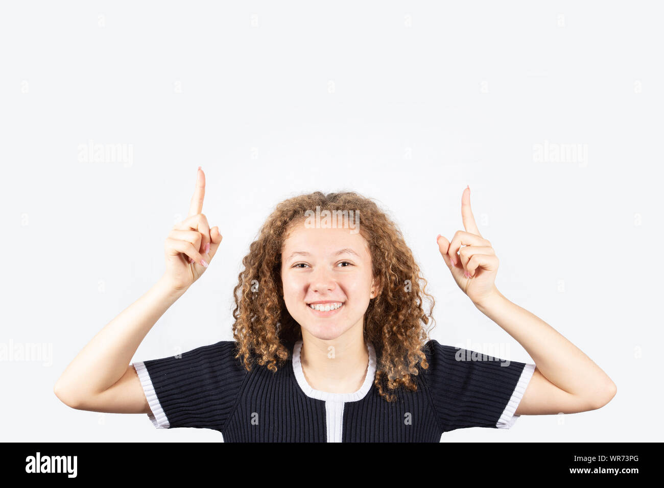 Portrait of happy teenage girl with curly hair smiling looking at ...
