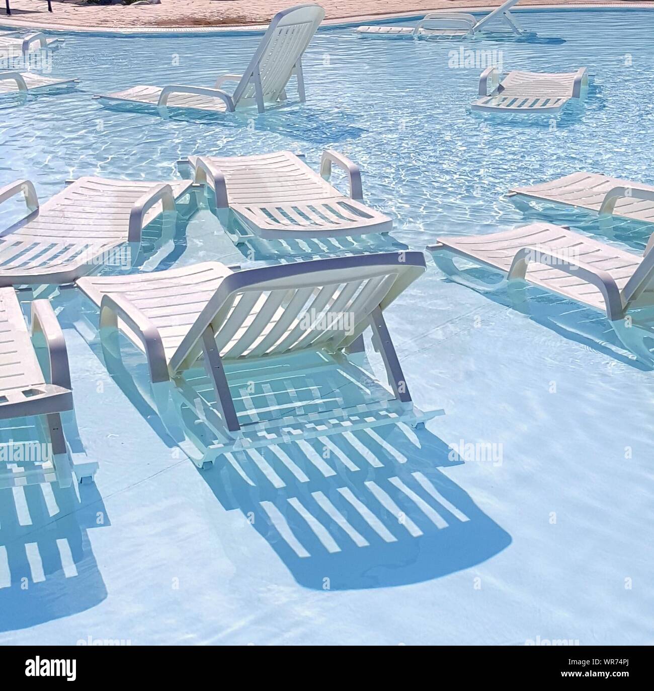 Empty Lounge Chairs In Swimming Pool Stock Photo Alamy