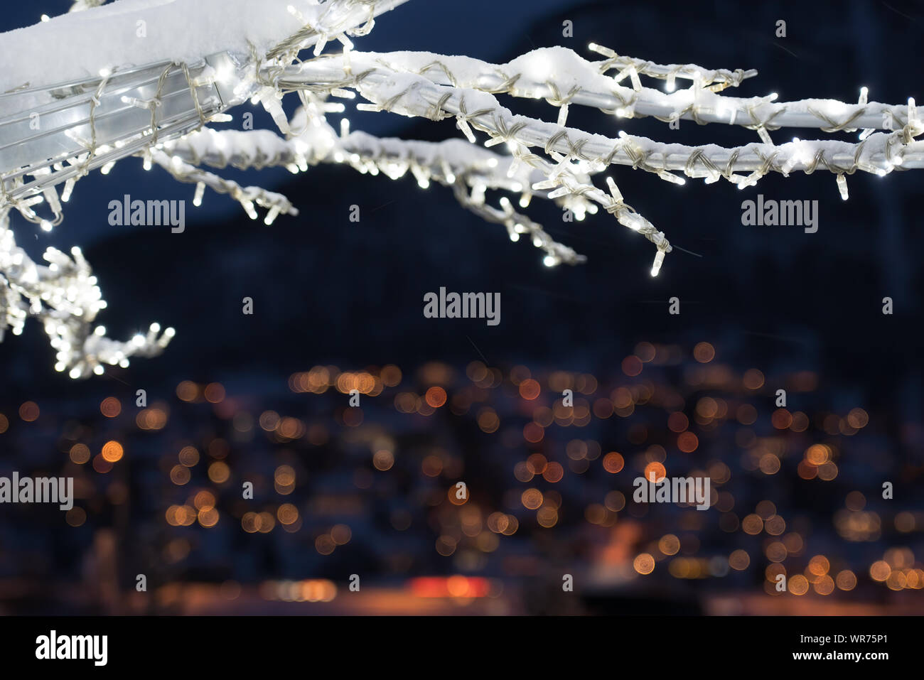 Winter tree with lights and decorations with the defocused city lights of Tromso town in the background, Northern Norway Stock Photo