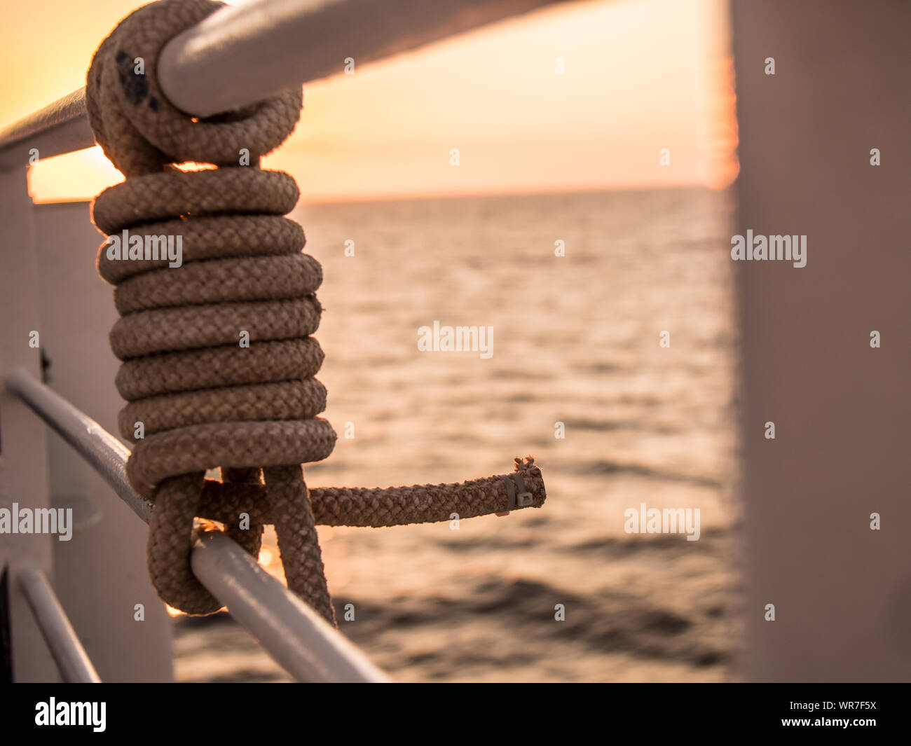 Rope knot closeup on a ship sailing in the ocean at sunest Stock Photo