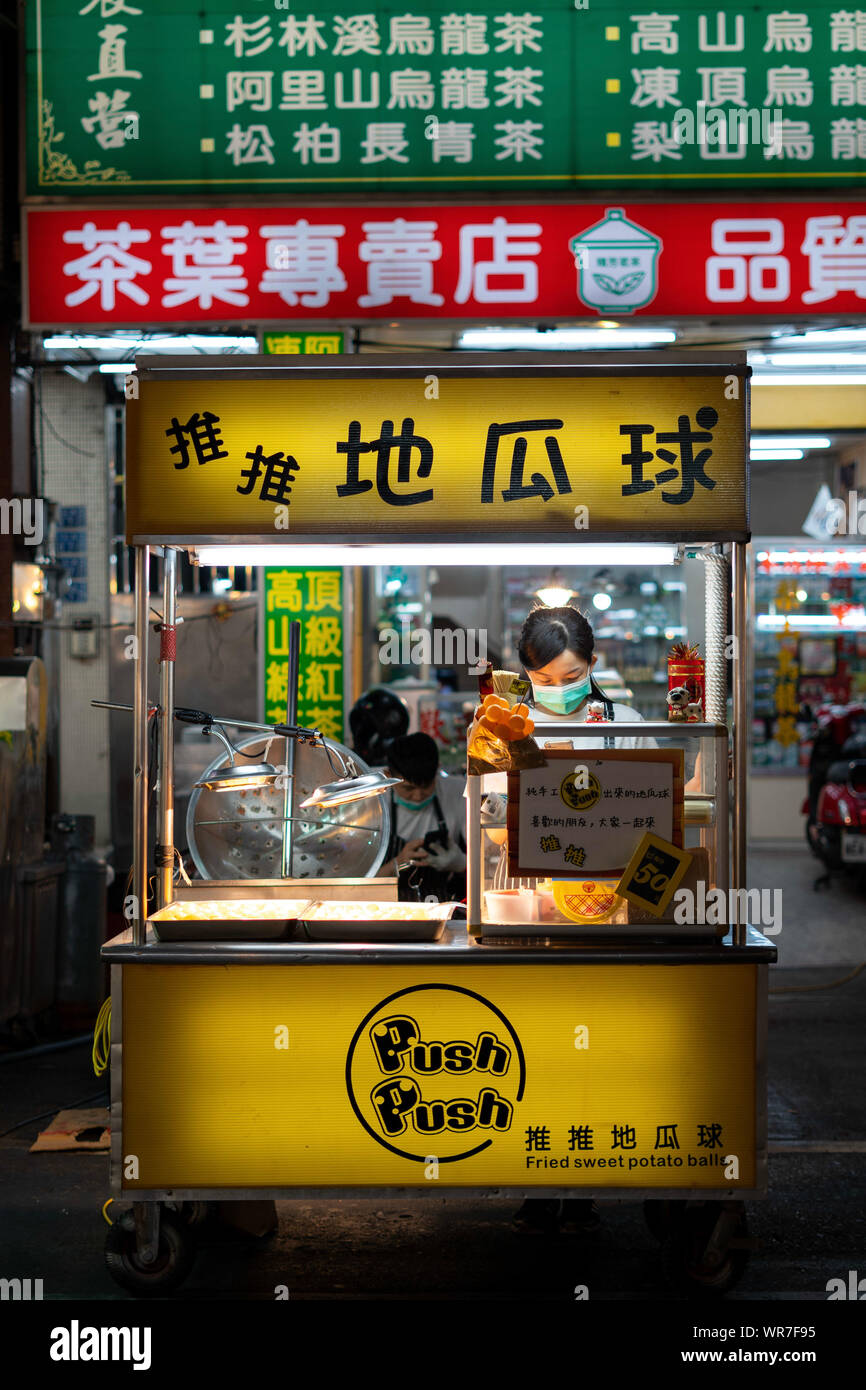 Kaohsiung, Taiwan: Small street food night market stall at Raohe Nightmarket selling taiwanese sweet potato balls, a delicious sweet and light snack. Stock Photo